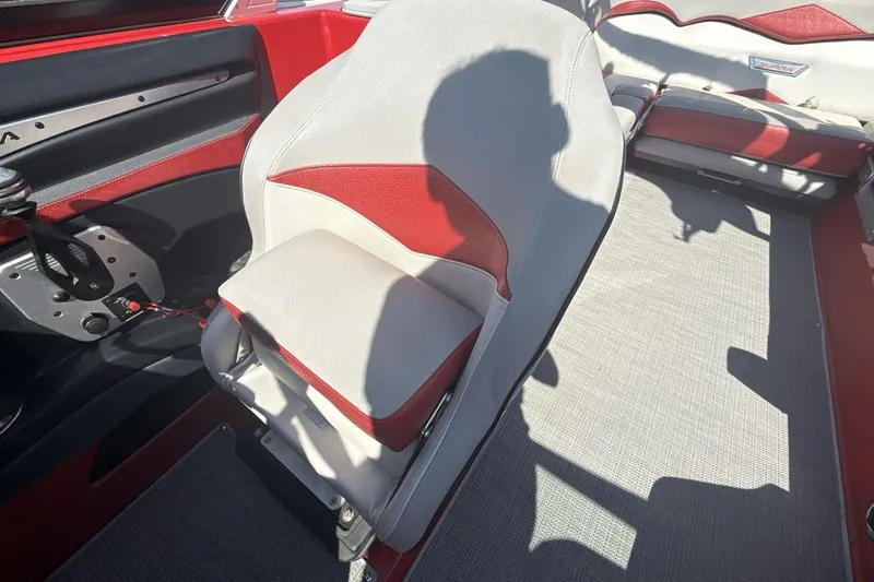 Slide: The Image of 2016 Supra SE 550 boat interior with red and gray seating and steering area. - 13