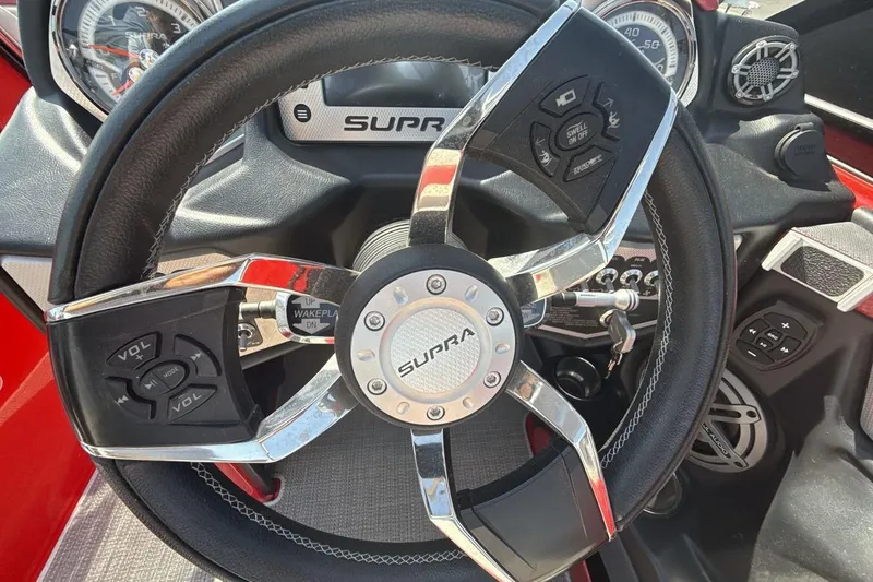 Slide: The Image of Steering wheel of a 2016 Supra SE 550 boat with control buttons. - 14