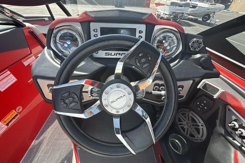 Slide: The Image of Steering wheel and dashboard of 2016 Supra SE 550 boat, featuring modern controls and gauges. - 15