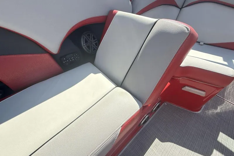 Slide: The Image of 2016 Supra SE 550 boat interior with red and gray seating and speaker system. - 24