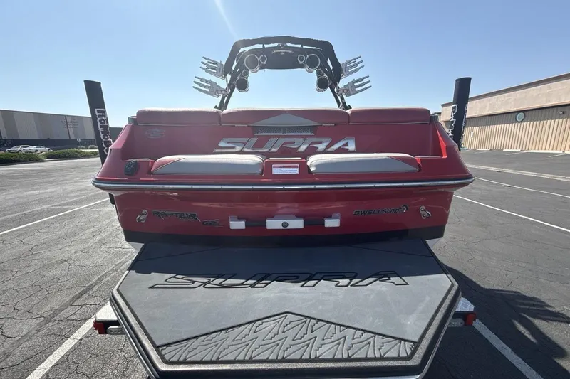 Slide: The Image of Red 2016 Supra SE 550 boat with wakeboard tower, parked in a lot. - 4
