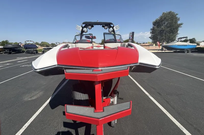 Slide: The Image of 2016 Supra SE 550 boat in red and white, parked in a lot under clear skies. - 8