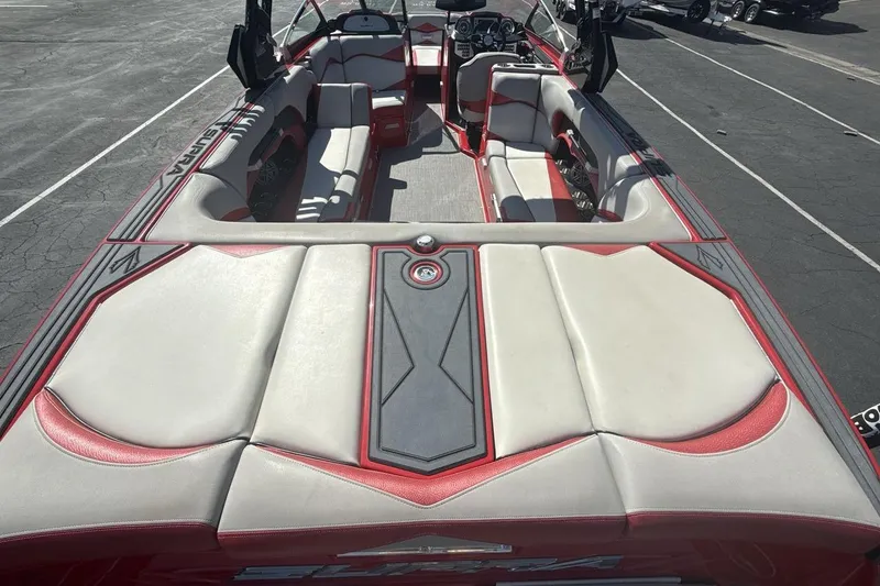 Slide: The Image of 2016 Supra SE 550 boat interior with red and white seating, parked on asphalt. - 9