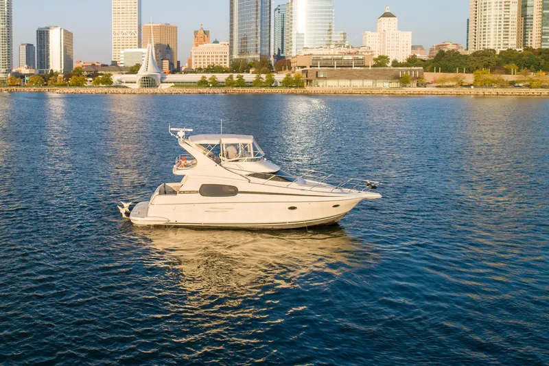 Slide: The Image of 2003 Silverton 410 Sport Bridge yacht on urban waterfront with city skyline backdrop. - 14