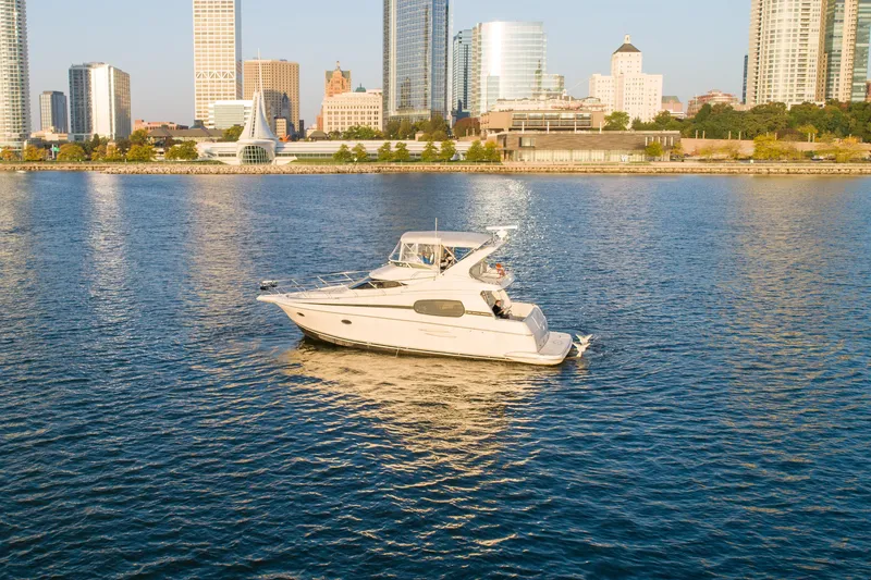 Slide: The Image of 2003 Silverton 410 Sport Bridge yacht on urban waterfront with city skyline backdrop. - 2