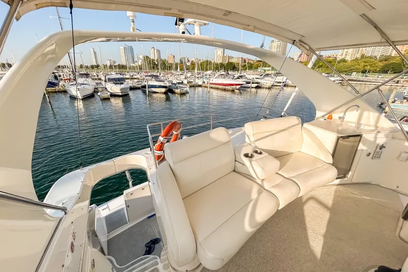 Slide: The Image of 2003 Silverton 410 Sport Bridge yacht interior with marina view, featuring white seating and amenities. - 22