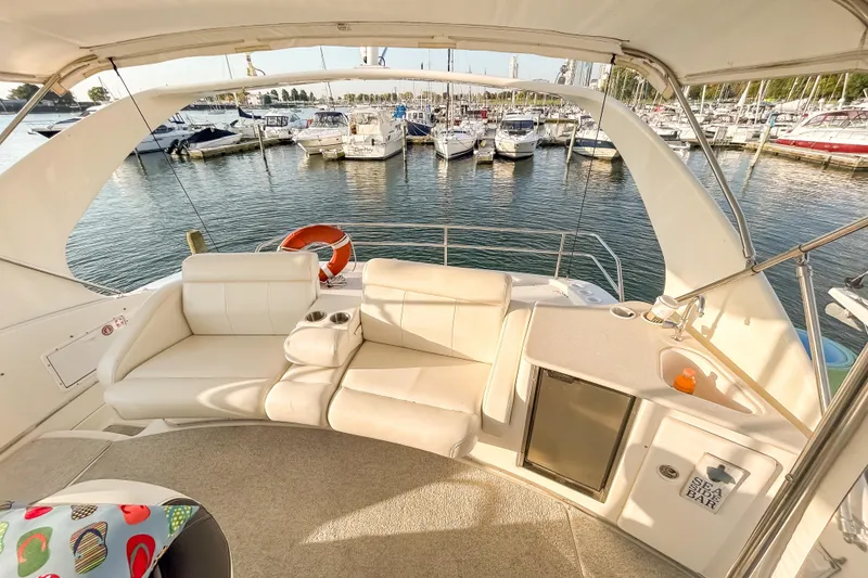 Slide: The Image of Luxurious 2003 Silverton 410 Sport Bridge yacht interior with seating and mini bar, docked at marina. - 23