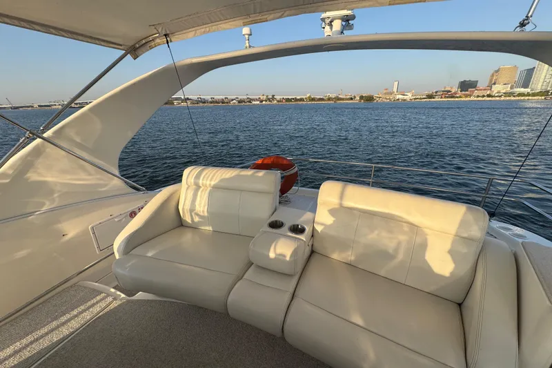 Slide: The Image of 2003 Silverton 410 Sport Bridge yacht with white seating, overlooking a calm waterfront. - 30