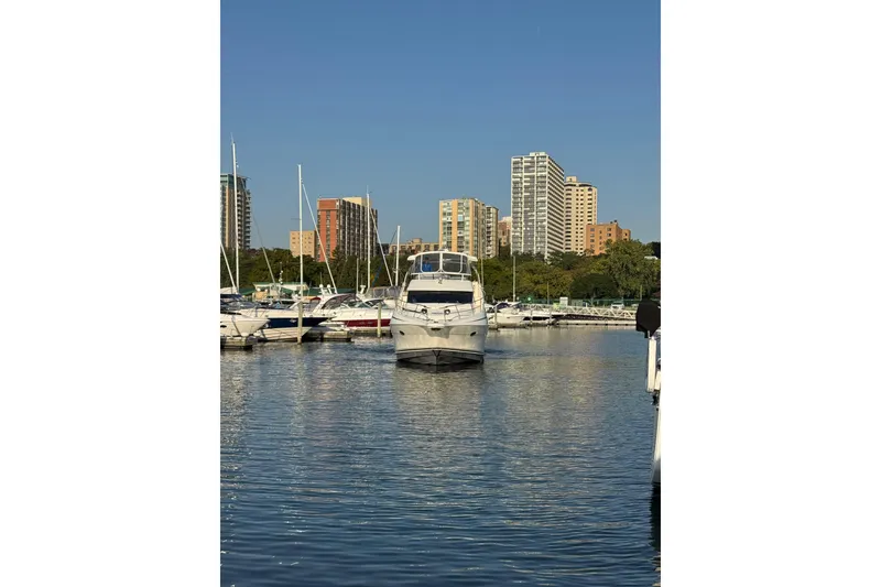 Slide: The Image of 2003 Silverton 410 Sport Bridge yacht docked in urban marina with city skyline. - 50
