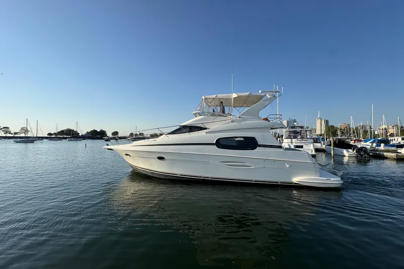 Slide: The Image of 2003 Silverton 410 Sport Bridge yacht docked in a marina under clear blue skies. - 57