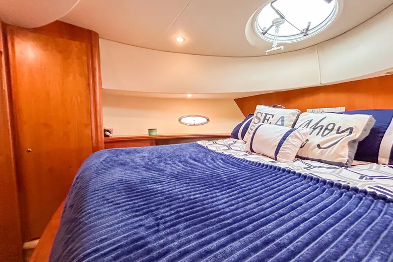 Slide: The Image of Luxurious cabin interior of 2003 Silverton 410 Sport Bridge with plush bedding and nautical decor. - 78
