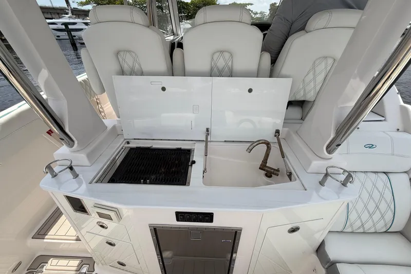 Slide: The Image of 2021 Regal 33 SAV boat interior with grill and sink setup. - 11