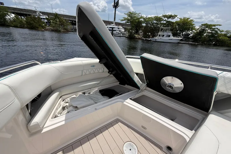 Slide: The Image of 2021 Regal 33 SAV boat with open storage compartments on a sunny day by the water. - 23