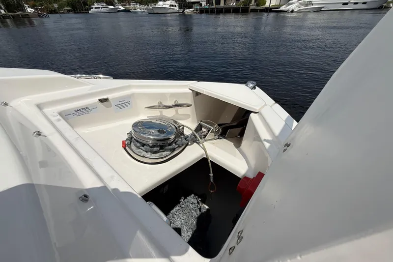 Slide: The Image of 2021 Regal 33 SAV boat anchor compartment with winch, docked on a calm waterway. - 24