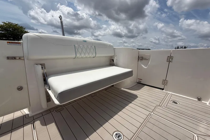 Slide: The Image of 2021 Regal 33 SAV boat with white seating and spacious deck under cloudy sky. - 9