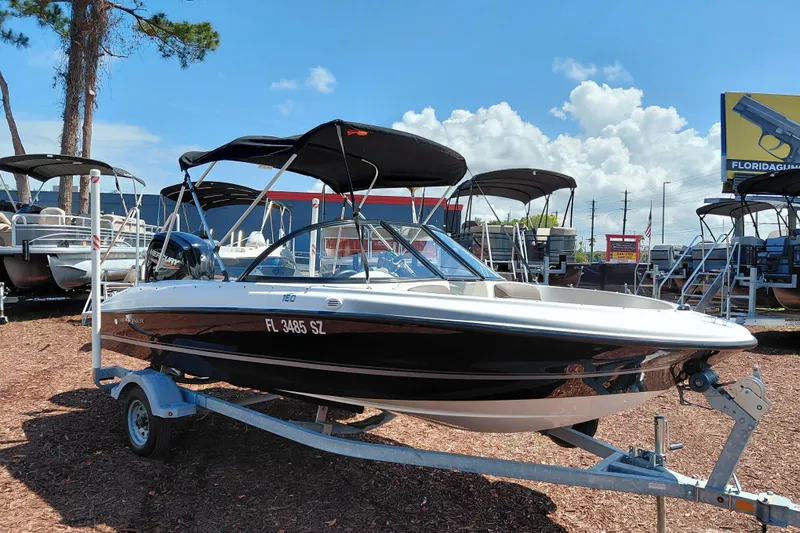 The Image of 2021 Bayliner 160 Bowrider boat on trailer, displayed outdoors under a clear sky. - 1