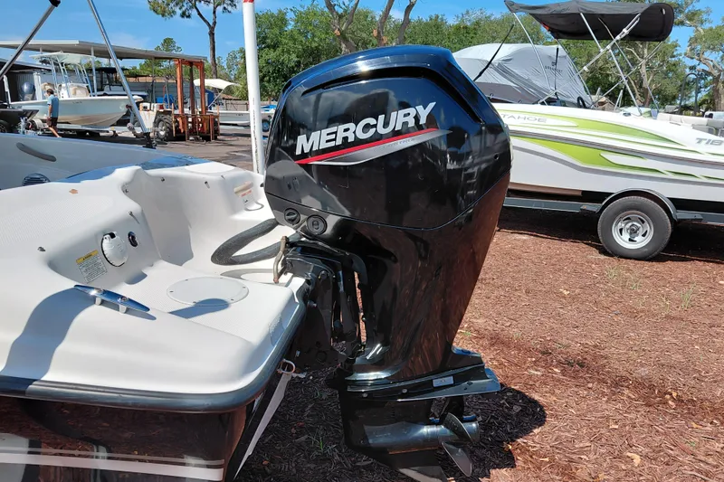 Slide: The Image of 2021 Bayliner 160 Bowrider with Mercury outboard motor in a boatyard setting. - 10