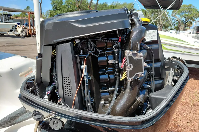 Slide: The Image of 2021 Bayliner 160 Bowrider outboard engine, detailed view in a sunny marina setting. - 11
