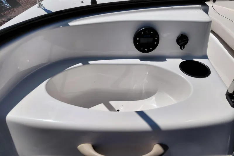 Slide: The Image of 2021 Bayliner 160 Bowrider dashboard with control panel and cup holder. - 17