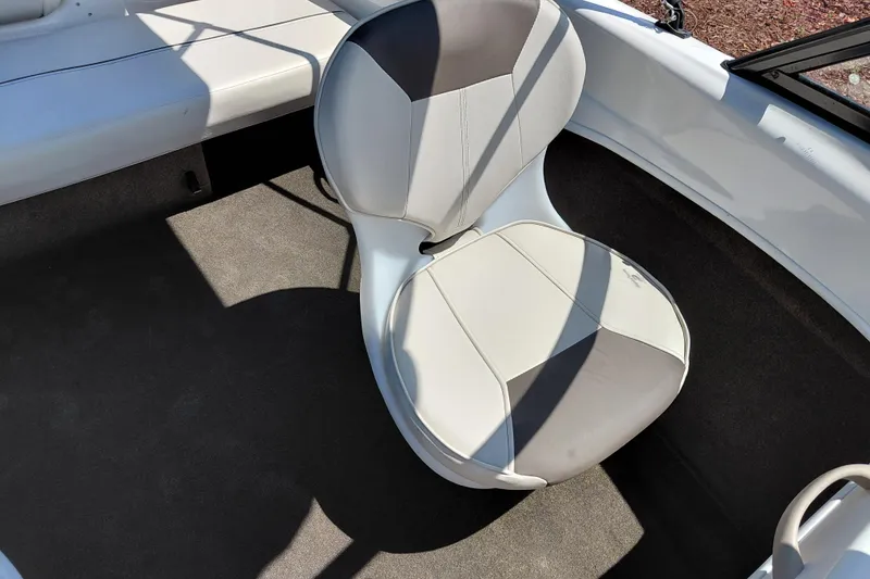 Slide: The Image of 2021 Bayliner 160 Bowrider interior with cushioned seating and carpeted flooring. - 19