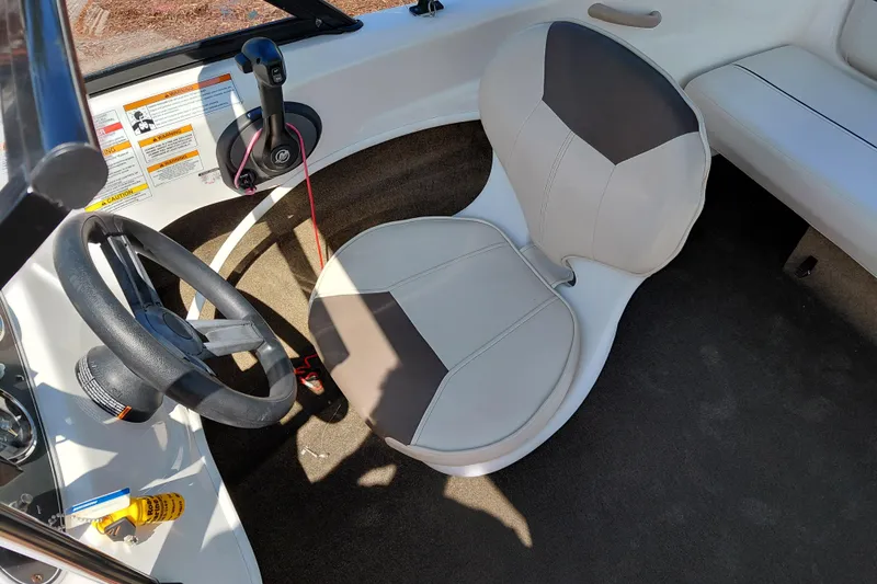 Slide: The Image of 2021 Bayliner 160 Bowrider interior with steering wheel and cushioned seat. - 20