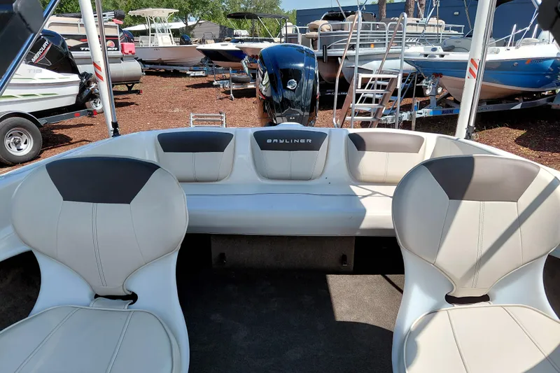 Slide: The Image of 2021 Bayliner 160 Bowrider interior with seating, displayed in a boatyard. - 22