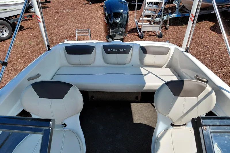 Slide: The Image of 2021 Bayliner 160 Bowrider interior with seating and outboard motor, showcasing spacious design. - 23