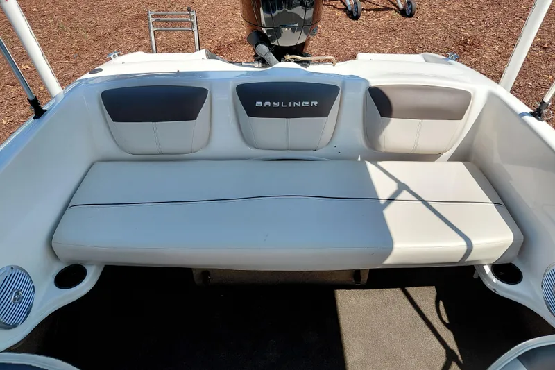 Slide: The Image of 2021 Bayliner 160 Bowrider boat interior with cushioned seating and cup holders. - 24