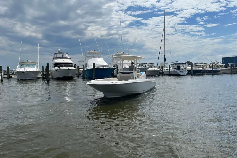 Slide: The Image of 2020 Boston Whaler 270 Dauntless boat docked in a marina under a partly cloudy sky. - 1