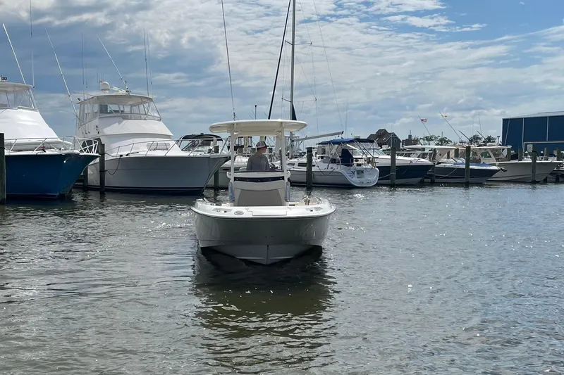 Slide: The Image of 2020 Boston Whaler 270 Dauntless boat docked at a marina under a partly cloudy sky. - 2