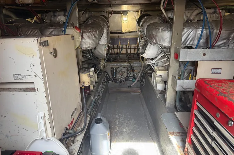 Slide: The Image of Engine room of a 1985 Hatteras 52 Convertible yacht, showcasing machinery and equipment. - 12