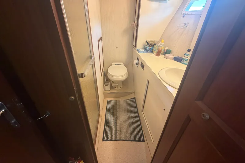 Slide: The Image of Bathroom interior of 1985 Hatteras 52 Convertible yacht, featuring toilet, sink, and shower. - 22