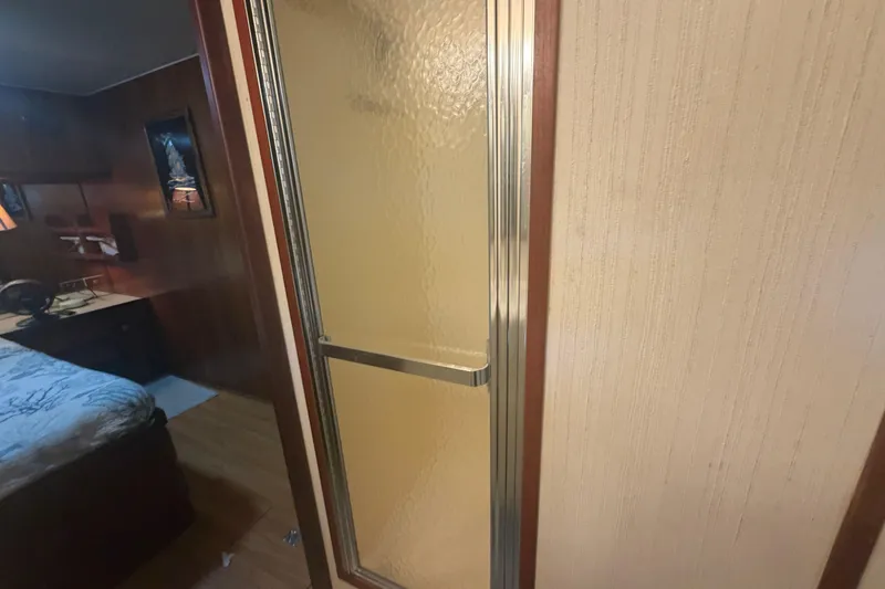 Slide: The Image of Interior of 1985 Hatteras 52 Convertible yacht showing a shower door and cabin area. - 25