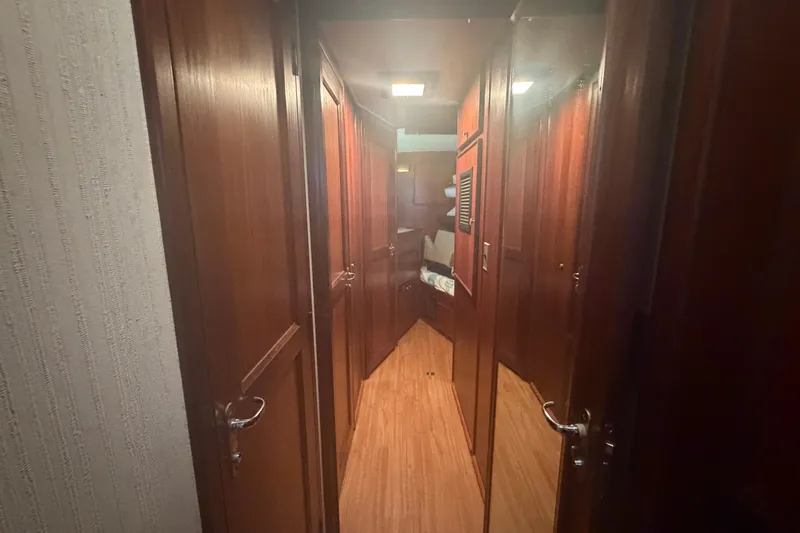 Slide: The Image of Interior hallway of 1985 Hatteras 52 Convertible yacht with wooden doors and flooring. - 38