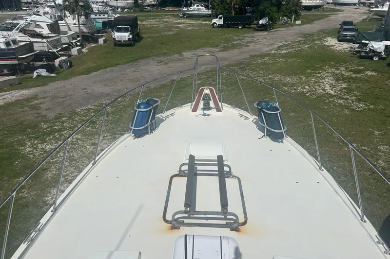 Slide: The Image of Bow view of 1985 Hatteras 52 Convertible yacht on land, surrounded by vehicles. - 41