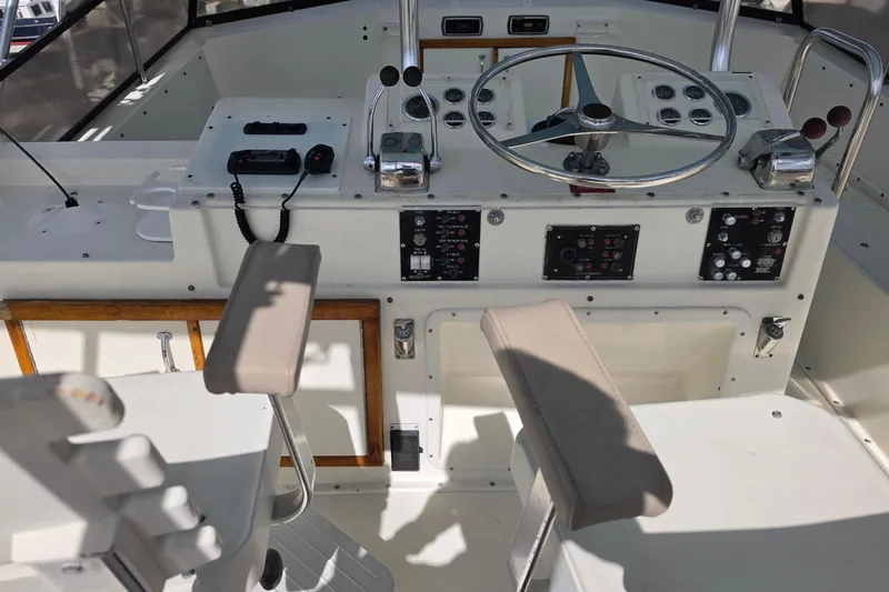 Slide: The Image of Cockpit of 1985 Hatteras 52 Convertible yacht with steering wheel and control panels. - 42