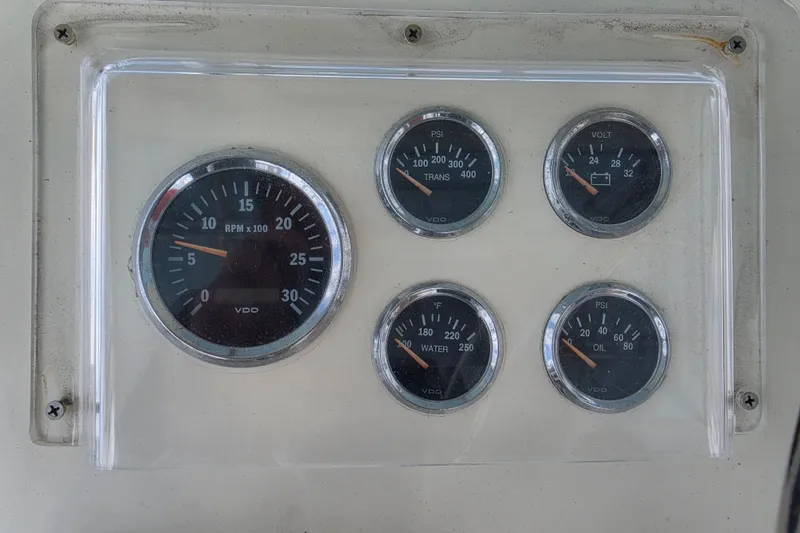 Slide: The Image of Dashboard gauges of a 1985 Hatteras 52 Convertible boat, displaying RPM, PSI, voltage, and temperature. - 45