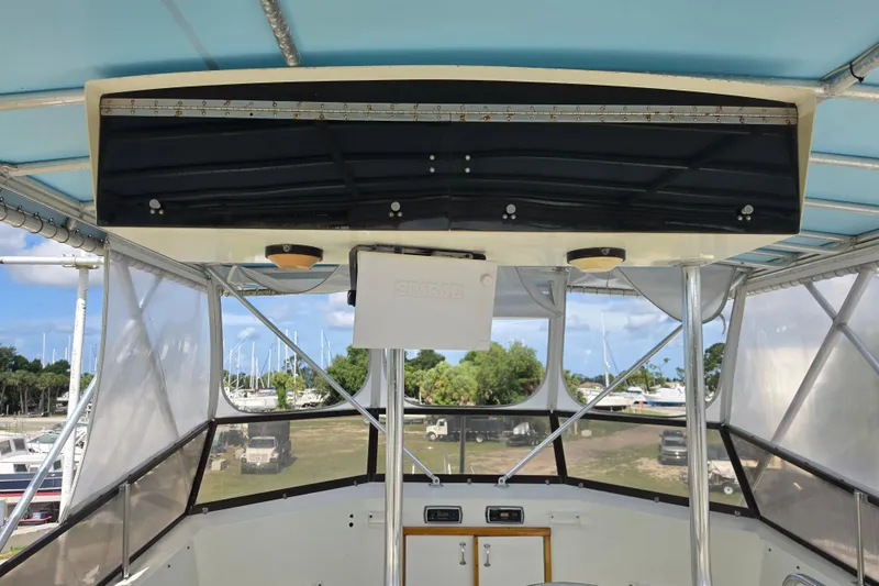 Slide: The Image of 1985 Hatteras 52 Convertible boat interior with navigation equipment and marina view. - 49