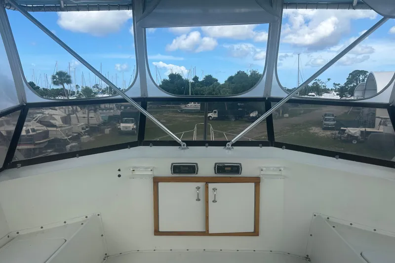 Slide: The Image of Interior view of 1985 Hatteras 52 Convertible yacht cockpit with marina background. - 56