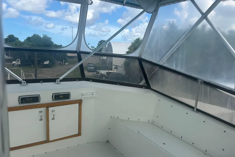 Slide: The Image of 1985 Hatteras 52 Convertible boat interior with clear windows and storage cabinets. - 57