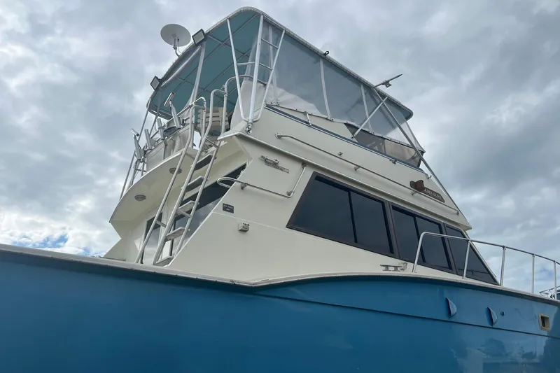 Slide: The Image of 1985 Hatteras 52 Convertible yacht with blue hull under cloudy sky. - 6