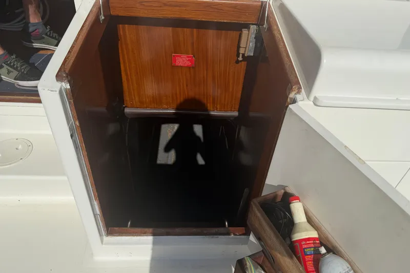 Slide: The Image of Hatteras 52 Convertible 1985 boat hatch with wooden door and storage compartment. - 63