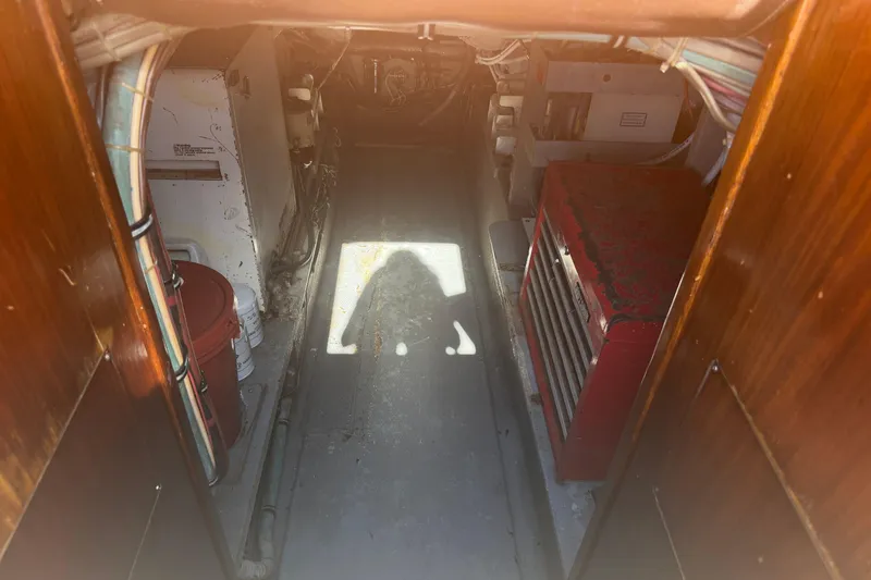 Slide: The Image of Engine room of 1985 Hatteras 52 Convertible yacht with visible equipment and storage. - 64