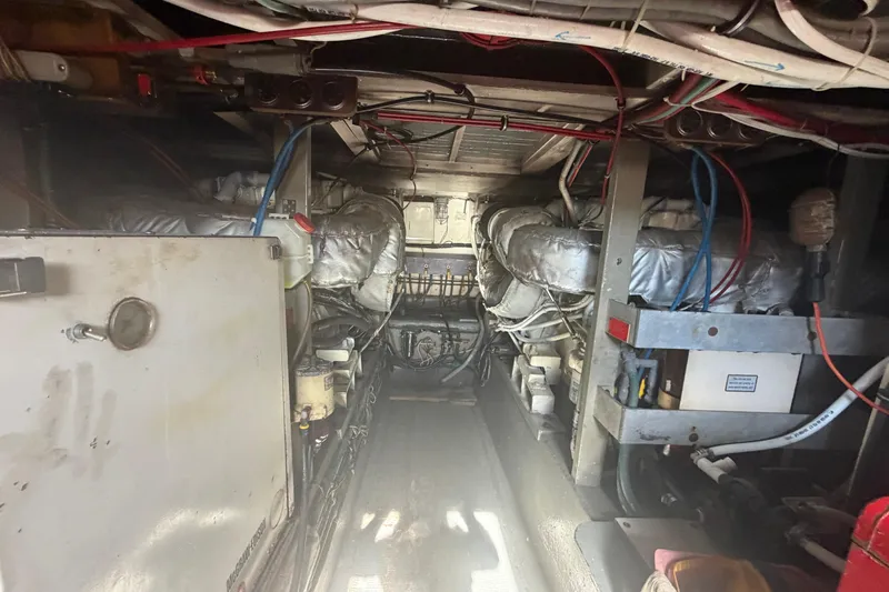 Slide: The Image of Engine room of a 1985 Hatteras 52 Convertible yacht, showcasing machinery and wiring. - 67