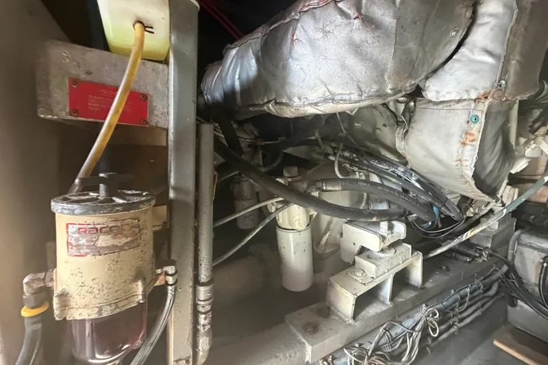 Slide: The Image of Engine room of a 1985 Hatteras 52 Convertible boat, showing mechanical components and wiring. - 72