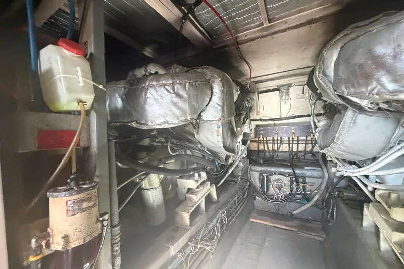 Slide: The Image of Engine room of a 1985 Hatteras 52 Convertible yacht, showcasing machinery and components. - 74
