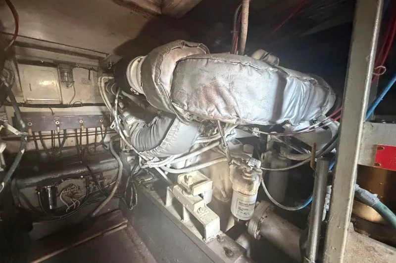Slide: The Image of Engine room of a 1985 Hatteras 52 Convertible yacht, showcasing mechanical components. - 77