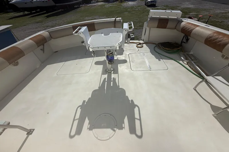 Slide: The Image of 1985 Hatteras 52 Convertible boat deck with fishing chair and cushioned seating. - 79