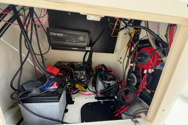 Slide: The Image of Electrical compartment of a 2017 Mako 21 LTS boat with wiring and battery setup. - 10