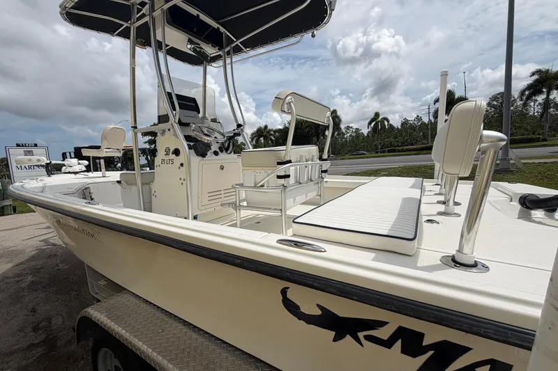 Slide: The Image of 2017 Mako 21 LTS boat with seating and console, parked on a trailer under cloudy skies. - 4